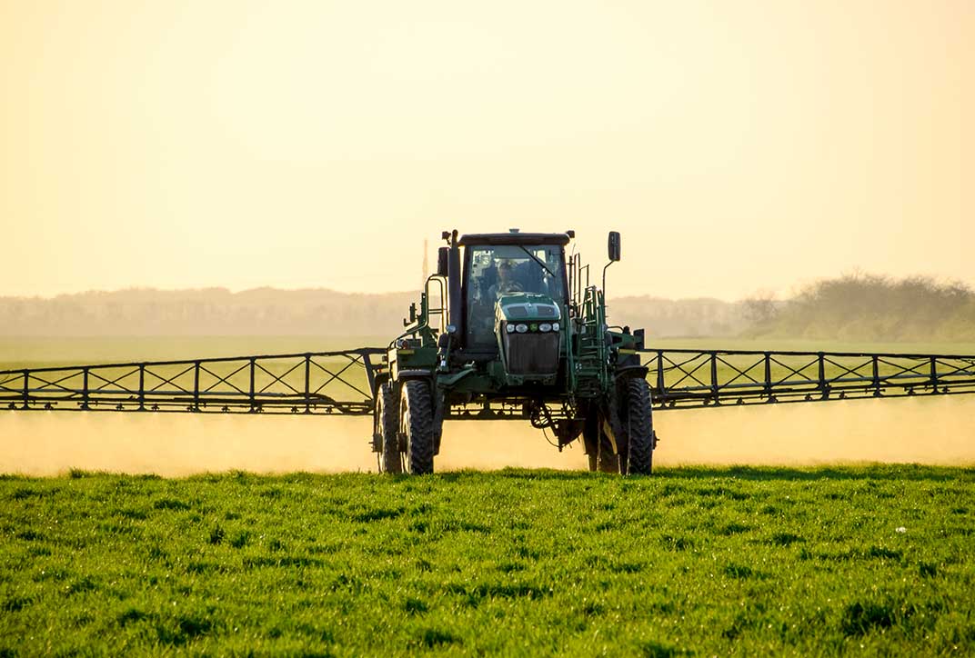 A tractor fertilizing a field.