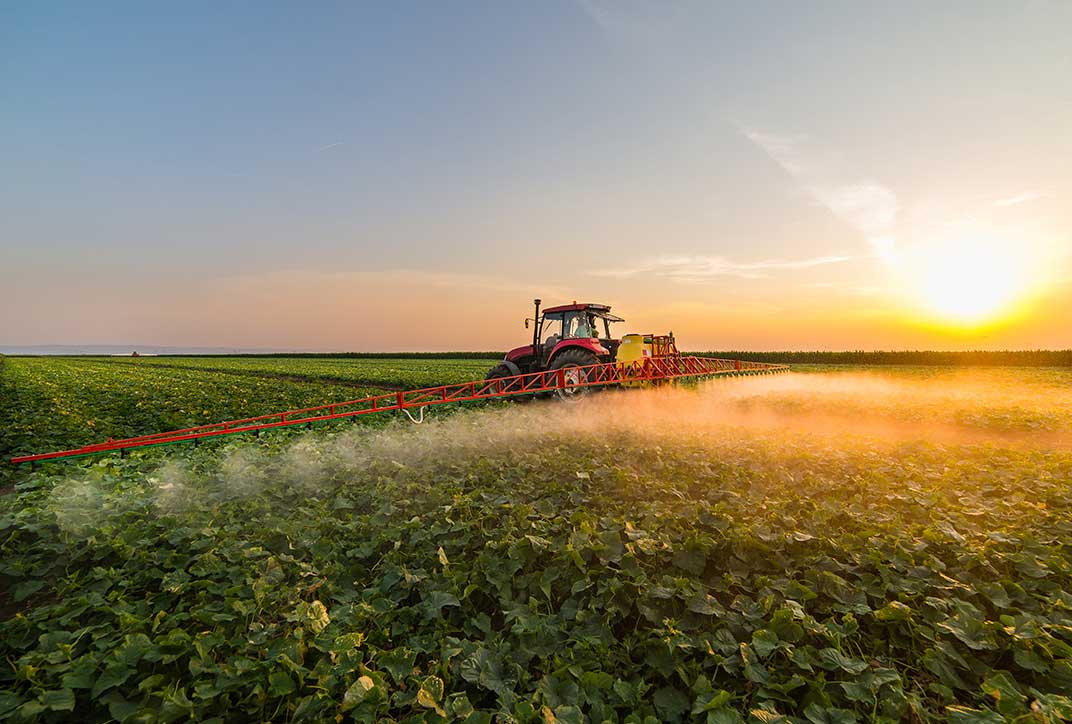 A tractor spraying fertilizer in a field.