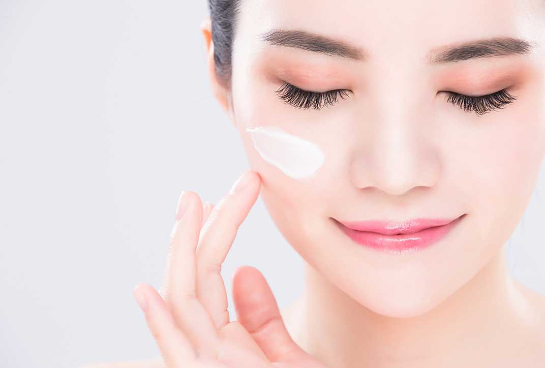 A lady applying face cream.