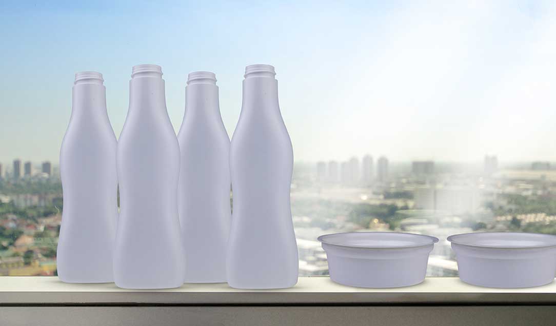 White plastic bottles and a white plastic tray against a blurred background