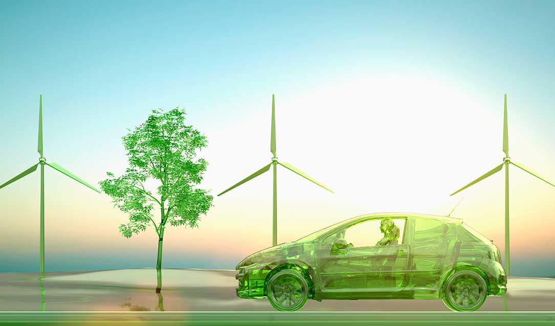 Transparent green car passing by wind turbines